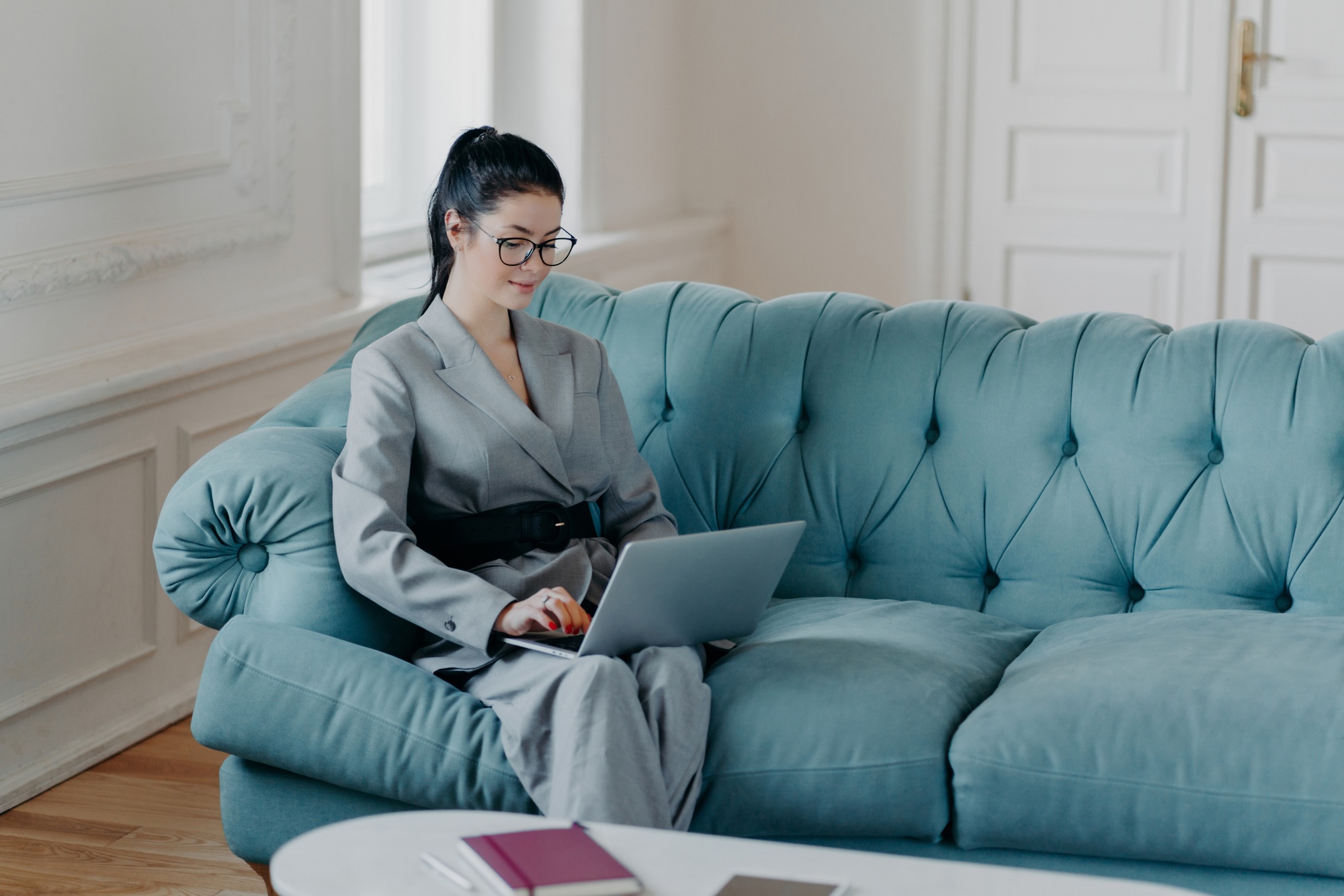 Businesswoman comfortably working from home on a laptop, exemplifying work-life balance.